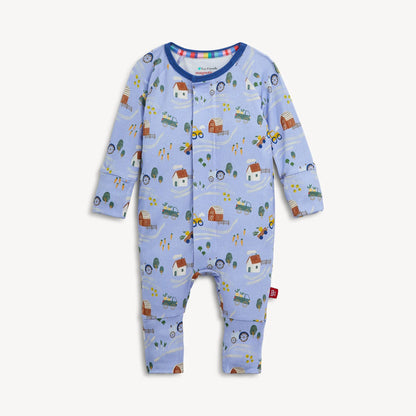 Introducing the Magnetic Me "Farm to Cradle" Magnetic Convertible Coverall by Magnetic Me: a light blue baby coverall with long sleeves, crafted from sustainable modal fabric and adorned with an adorable farm-themed print featuring tractors, barns, trees, and animals. This coverall features innovative magnetic closures down the front and legs for effortless changing.