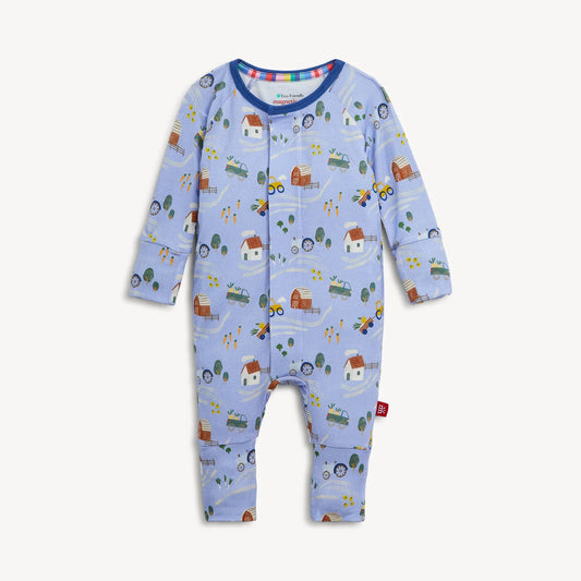 Introducing the Magnetic Me "Farm to Cradle" Magnetic Convertible Coverall by Magnetic Me: a light blue baby coverall with long sleeves, crafted from sustainable modal fabric and adorned with an adorable farm-themed print featuring tractors, barns, trees, and animals. This coverall features innovative magnetic closures down the front and legs for effortless changing.