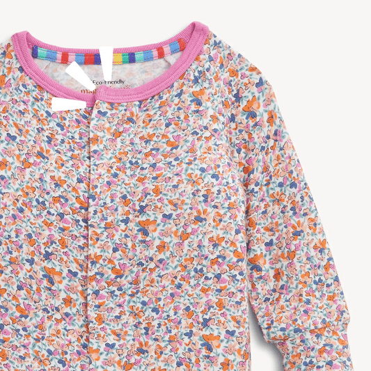 The Magnetic Me "Stella" Magnetic Convertible Coverall by Magnetic Me features a colorful floral and butterfly print, pink trim at the neck, and rainbow stripes lining the collar.