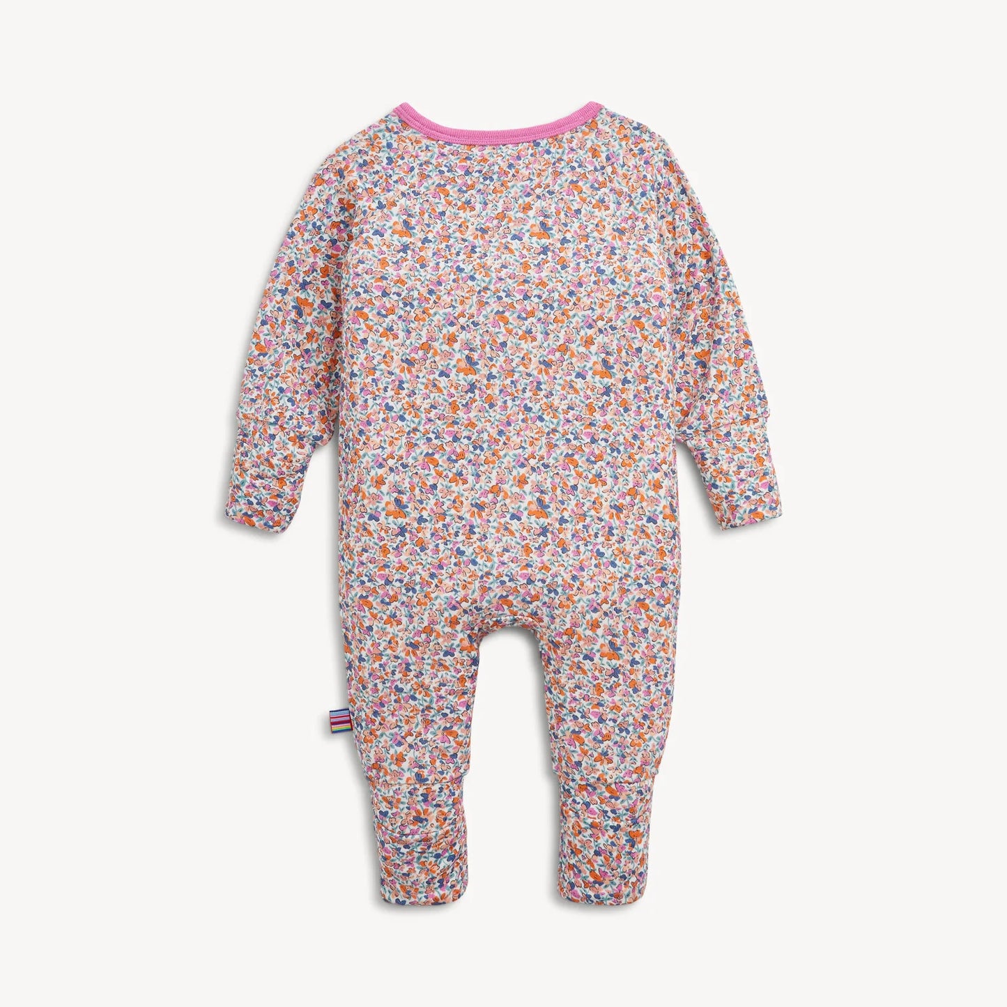 The Magnetic Me "Stella" Magnetic Convertible Coverall by Magentic Me is a baby onesie with long sleeves and legs, featuring an all-over floral print in various colors and a pink neckline, displayed on a white background.
