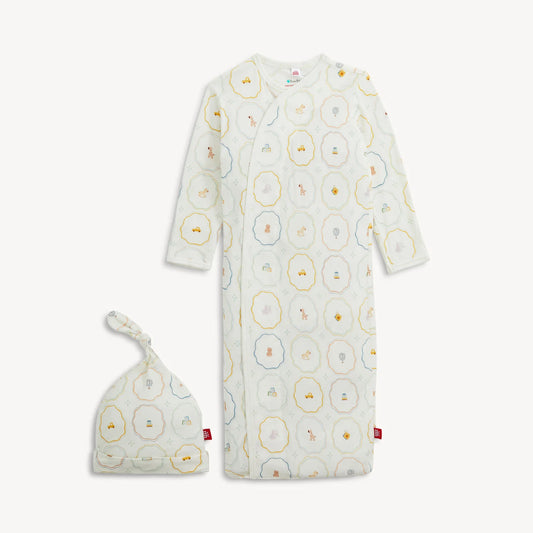 The Magnetic Me Nursery Magic Magnetic Gown & Hat Set by Magnetic Me features a soft TENCEL™ modal gown with long sleeves and a matching knotted hat, both adorned with playful animal and geometric prints in pastel shades. The gown is designed with handy magnetic closures for effortless dressing.