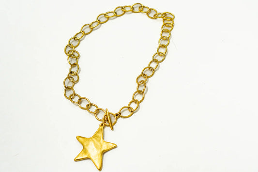Coastal Grit Antique Star Pendant in gold on chunky gold link bracelet