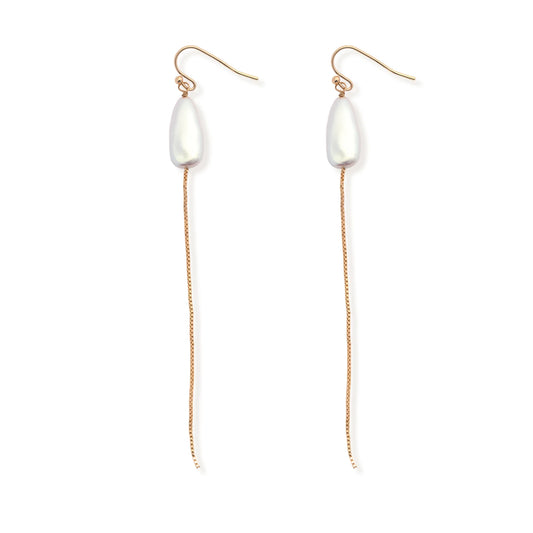 The Leslie Curtis "Pearl" Earrings by Leslie Curtis showcase elongated white pearls suspended from long, delicate gold chains and gold hooks, reminiscent of a matching pearl necklace, and are displayed on a white background.