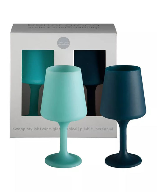 Two stemmed Porter Green Unbreakable Wine Glasses—one in light blue and one in dark blue—stand in front of a Porter Green box with cut-out windows showcasing a set of 2 identical glasses inside. The box features descriptive text along the bottom.