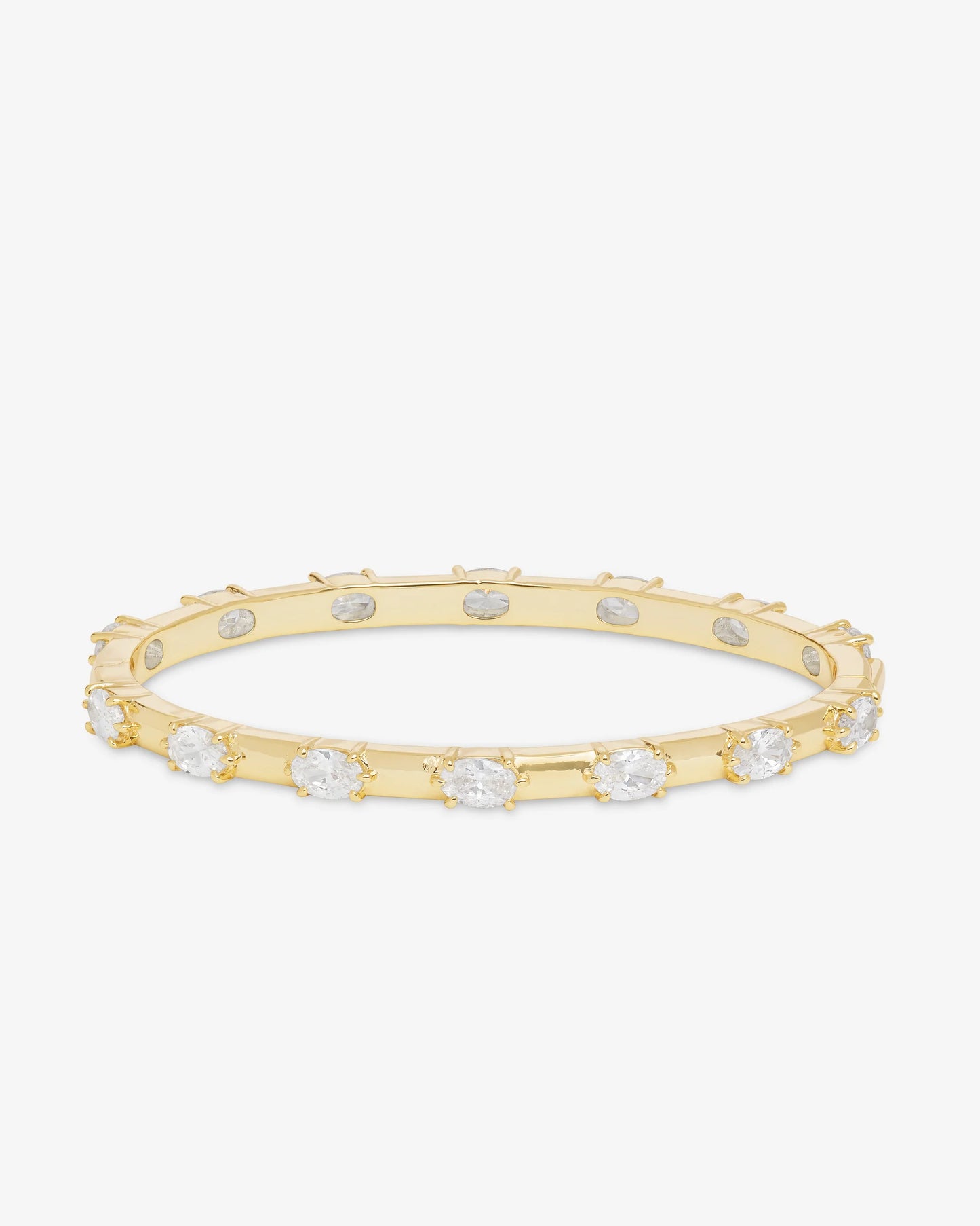 The Melinda Maria She's On Point Station Cuff by Melinda Maria is a gold-plated bangle bracelet adorned with evenly spaced round white gemstones, exuding the timeless elegance of a classic simulated diamond design, and is showcased against a plain white background.