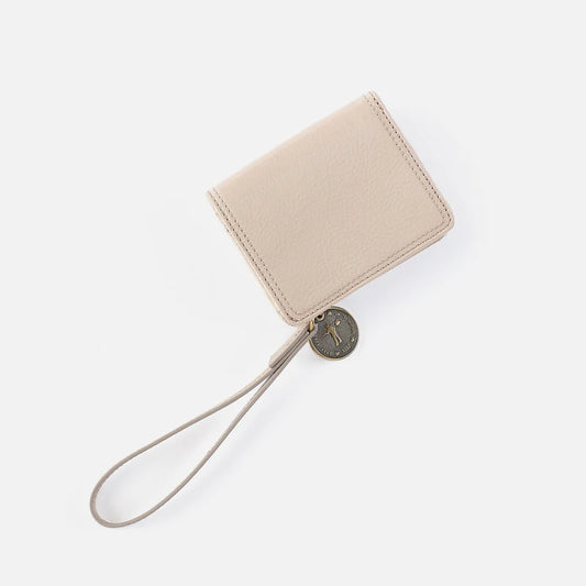 Hobo Coin Wristlet Wallet in stone gloss leather with wrist strap and metal charm