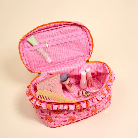 The Darling Effect Glam & Go Quilted Cosmetic Bag open showing pink quilted interior with organizational pockets and cosmetics inside