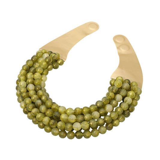 Sensibling Corp. marbled ball beaded magnetic collar necklace with olive-green beads and cream faux leather backing, flat lay