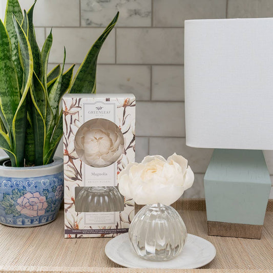 Greenleaf Gifts Magnolia Diffuser styled on marble surface with potted plant, lamp, and decorative box in home setting