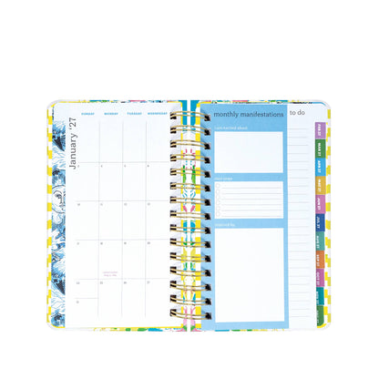 The Lilly Pulitzer by Lifeguard Press - Medium 17 Month Agenda, Lovely Lilly features an open spiral-bound design with a monthly calendar for January 2024 on the left and dedicated sections on the right for monthly manifestations, to-do lists, and easy-to-find categorized tabs along the page edge—ideal for lovers of colorful organization or anyone looking to add that signature Lilly Pulitzer agenda charm to their planning routine.