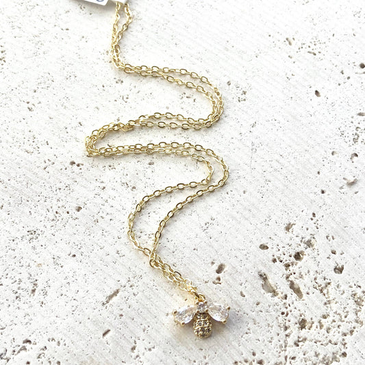VB&CO Designs gold bee necklace full length showing long chain with bee pendant on white surface