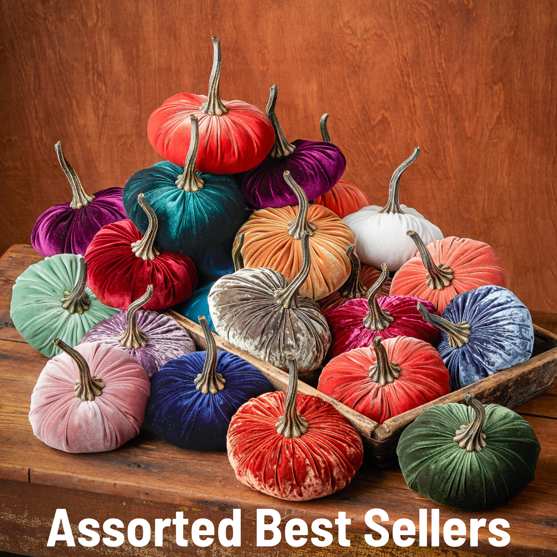 A selection of large velvet pumpkins from Your Heart’s Content is beautifully displayed on wooden surfaces, offering the ideal handcrafted fall mantel or Halloween table decor for your home. The text “Assorted Best Sellers” is featured at the bottom of the image.