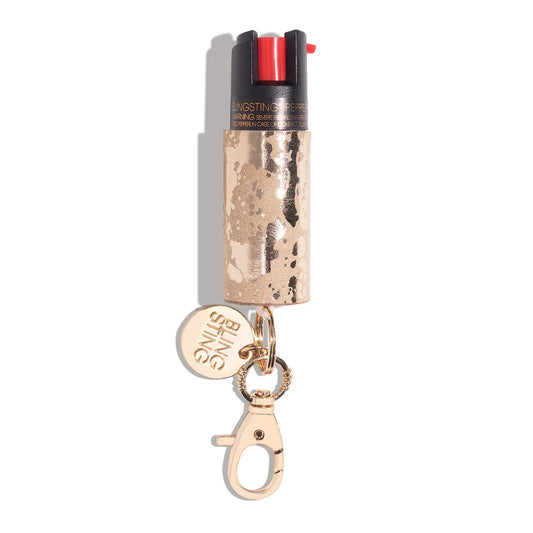 Bling Sting pepper spray in rose gold sequin finish with gold keychain clip and red safety cap
