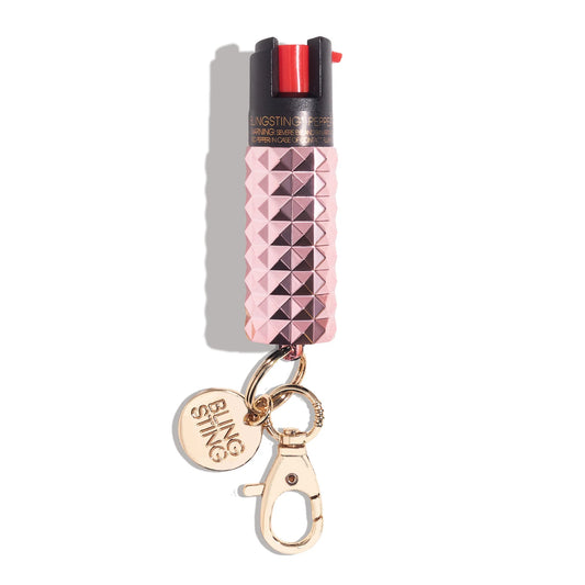 Bling Sting pepper spray with pink studded body, black top, red trigger, and gold keychain clip