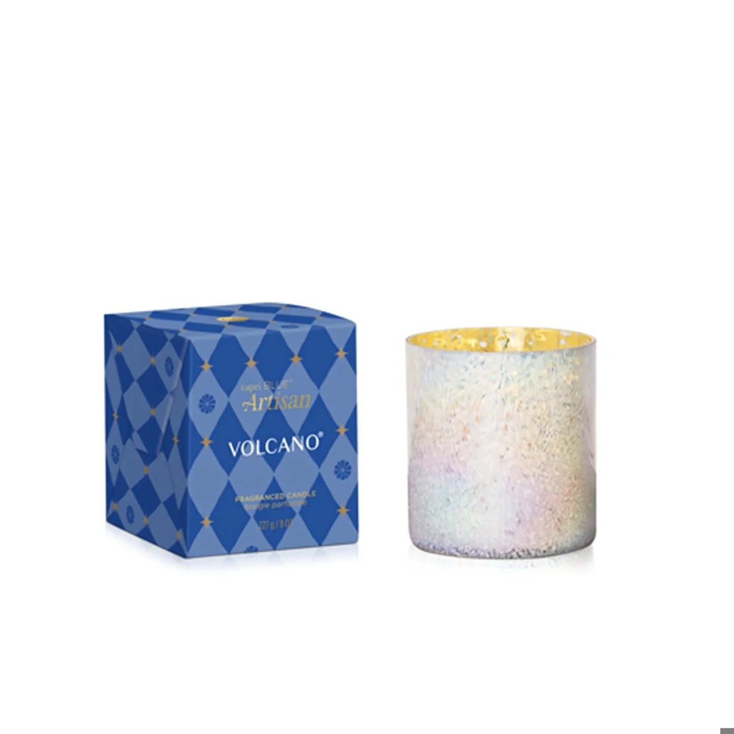 A Capri Blue Volcano Winter Bazaar Boxed Tumbler candle, featuring a festive blue gift box with gold accents, sits beside an iridescent white glass jar on a white background, lending an elegant touch and the spiced fragrance signature to Capri Blue.