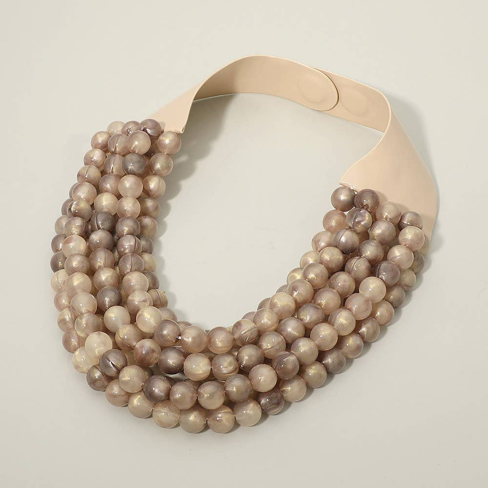 The Sensibling Corp. Marbled Ball Beaded Multi Layered Faux Leather Magnetic Collar Necklace showcases a bold, chunky silhouette with five strands of round, glossy beige and light brown marbled beads, finished with a wide, flat cream-colored magnetic clasp for a striking layered collar look.