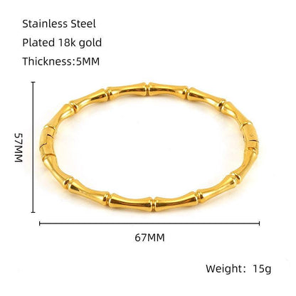 Introducing the Mio Queena - Multi-style 18K Gold-plated Stainless Steel Bangle (FGS), a bamboo-inspired bracelet from Mio Queena. Expertly crafted from durable stainless steel and finished with lustrous 18K gold plating, this bangle features a 67mm inner diameter, 75mm outer diameter, and a sleek 5mm thickness, weighing just 15g. Ideal as an elegant jewelry gift, it is beautifully showcased on a white background with product name, text, and measurements displayed beside the bracelet.