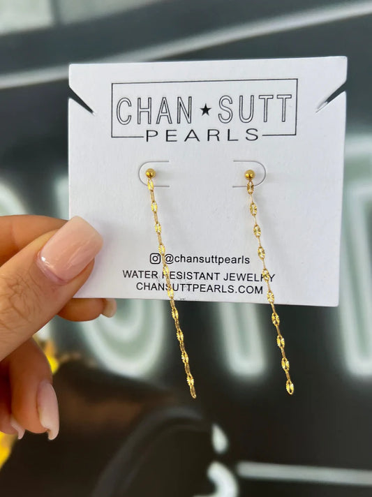 CHANSUTTPEARLS dainty chain earrings in gold on branded product card held in hand