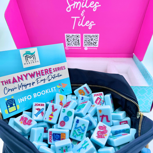 My Fair Mahjong Anywhere Series unboxed showing pink box, black carrying pouch with gold zipper, info booklet, and light blue tiles inside