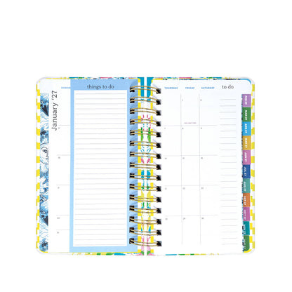 A Lilly Pulitzer by Lifeguard Press - Medium 17 Month Agenda, Lovely Lilly, lies open with a "things to do" list on the left page and a monthly calendar for January 2024 on the right. Vibrant tabs organized along the edge mark each month in this colorful planner.