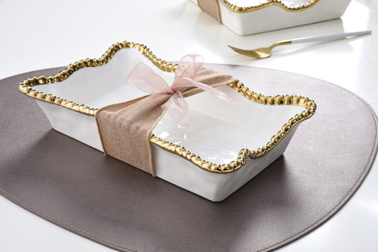 Pampa Bay white napkin holder with gold scalloped rim, tied with pink ribbon, on gray placemat