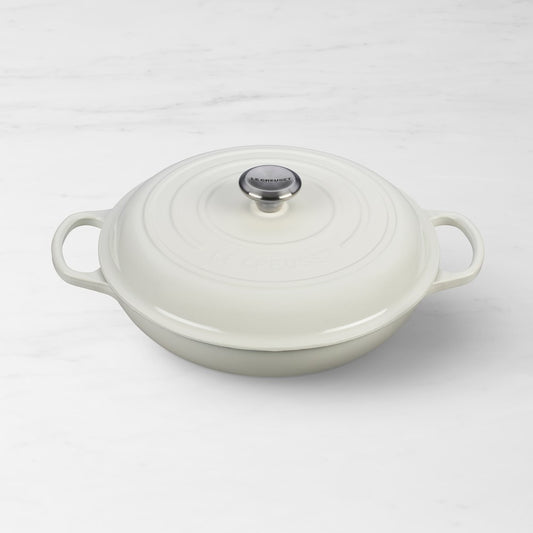 Le Creuset cream enameled cast iron signature braiser with domed lid, angled three-quarter view
