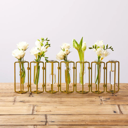 Tozai Home hinged flower vases filled with white carnations and green stems on wooden surface