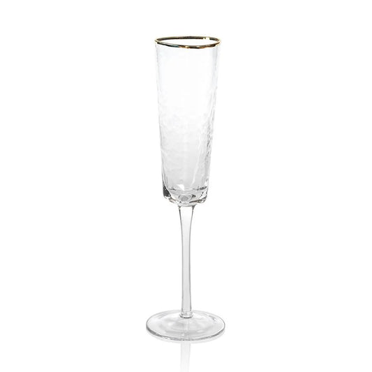 The Zodax "Kampari" champagne flute is a clear, textured glass with a long stem and a delicate gold rim, shown standing upright on a white background.