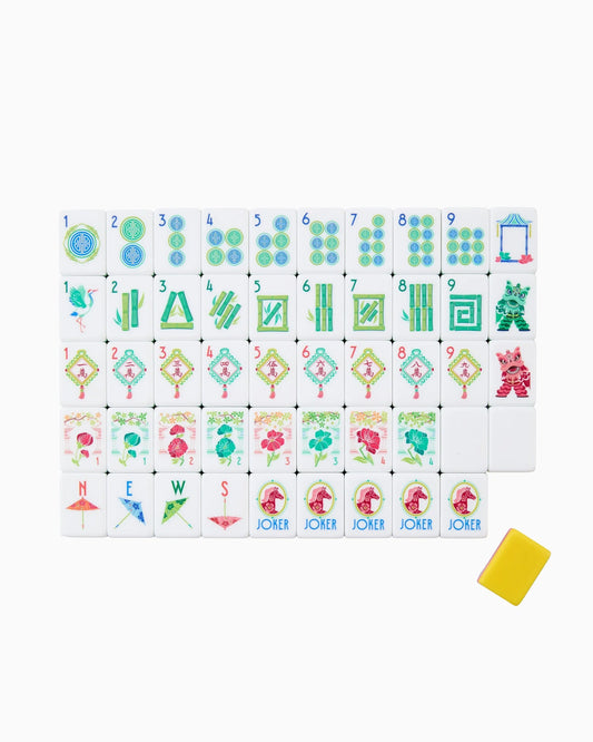 A set of Oh My Mahjong Pippa Tiles by Oh My Mahjong is arranged in rows, showcasing a variety of modern mahjong tiles with vibrant designs and numbers, including circles, bamboo, flowers, jokers, and a yellow tile case on the right.