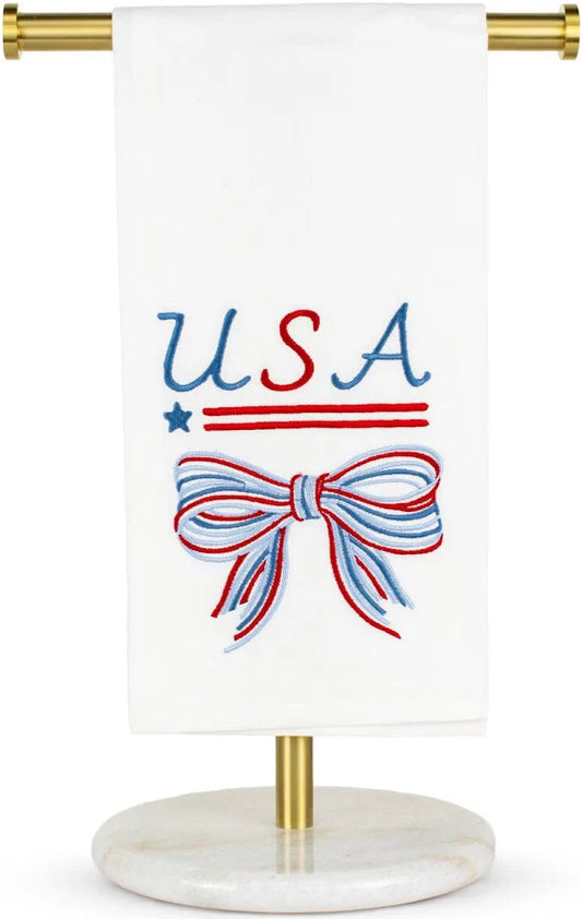 The Royal Standard Bow Hand Towel with USA text, star, and red-blue striped bow on white, displayed on brass stand