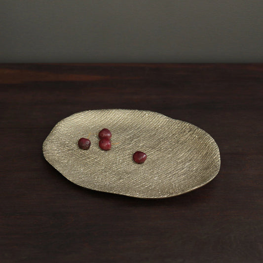 Beatriz Ball Sierra Kioto Oval Platter in gold with textured surface holding three red grapes