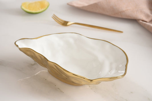 Pampa Bay Small Oyster Bowl with white interior and gold exterior, styled with lime wedge and fork