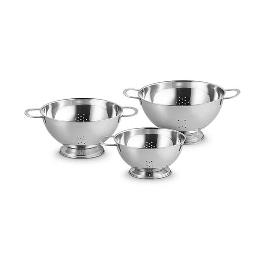 Three stainless steel Le Creuset colanders in graduated sizes with perforated bases and handles